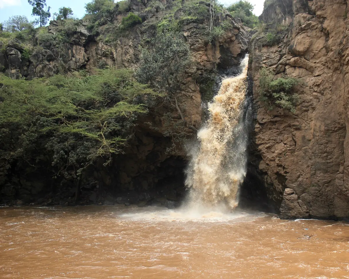 Makalia Falls dropping over a rock face into a brown pool